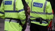 A woman and a young girl wearing a t-shirt of US singer Ariana Grande talks to police near Manchester Arena following a deadly terror attack in Manchester, northwest England on May 23, 2017.  AFP / Oli SCARFF
