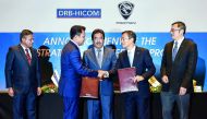Group Managing Director DRB-HICOM Berhad Syed Faisal Albar (second left) and Executive Vice President and CFO Zhejiang Geely Holding Group Daniel Li (Li Donghui) shake hands as Malaysia's Minister of Finance II Johari Abdul Ghani (centre), witnessing the 