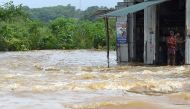 Sri Lankan residents stand in the doorway of a building surrounded by floodwaters in the suburb of Kaduwela in the capital Colombo on May 26, 2017. AFP / Ishara S. Kodikara 