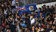 In this picture taken on April 25, 2017, a fan (C) of Hong Kong's Eastern waves the old British colonial flag of Hong Kong during the AFC Champions League football match between China's Guangzhou Evergrande and Hong Kong's Eastern at Mongkok Stadium in Ho