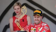 7Ferrari’s Sebastian Vettel celebrates winning the race on the podium with the trophy. (Reuters / Max Rossi)