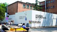 A tricycle drives past the construction site of the Hyundai Motor Studio in Beijing, China.