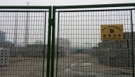 FILE PHOTO: Aluminium ingots are seen piled up behind a locked gate of a bonded storage area at the Dagang Terminal of Qingdao Port, in Qingdao, Shandong province June 7, 2014. To match Special Report CHINA-COLLATERAL/FAKE REUTERS/Fayen Wong