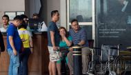Relatives of a victim sit in front of the Resorts World Hotel following an assault in Manila on June 2, 2017. Thirty-four bodies were found in a casino complex after a gunman started a fire in the building, the local police chief said. (AFP / NOEL CELIS)