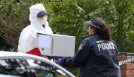 Australian police carry a box as they search what is believed to be the home of gunman Yacqub Khayre, who was shot dead by police on Monday after he shot a man dead and held a woman hostage, in the Melbourne suburb of Roxburgh Park in Australia, June 6, 2