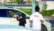 Ooredoo volunteers gift water and dates to a motorist at Aspire Zone.
