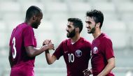 Abdul Kareem Hassan (left) of Qatar celebrates with team-mates after scoring a goal.