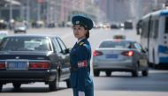In a photo taken on June 5, 2017 a traffic security officer stands on duty at an intersection in Pyongyang. AFP / Ed Jones