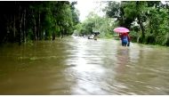 People walk in floodwaters following landslides triggered by heavy rain in Khagrachari, Bangladesh, in this still frame taken from video June 13, 2017. REUTERS/REUTERS TV.