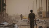 Syrian Democratic Forces (SDF) fighters walk on the rubble of a damaged street in the Raqqa's al-Sanaa industrial neighbourhood, Syria June 14, 2017. Picture taken June 14, 2017. REUTERS/Rodi Said
