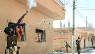 Kurdish fighters from the People's Protection Units (YPG) fires rifles at a drone operated by Islamic State militants in Raqqa, Syria, yesterday.
