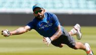 India's captain Virat Kohli dives to make a catch as he attends a nets practice session at The Oval in London on June 17, 2017, on the eve of the ICC Champions Trophy Final cricket match between India and Pakistan. (AFP / Ian KINGTON)