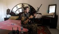 A member of the Kurdish People's Protection Units (YPG) sits in a bedroom as he holds a position in the al-Dariya neigbourhood of the Syrian city of Raqa, on June 18, 2017, during an offensive by US-backed fighters to retake the Islamic State (IS) group b