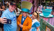This photo courtesy of Disney shows Huntington Beach, California, resident Jeff Reitz snaps a selfie with The Mad Hatter and Alice after a teacup ride at the Mad Tea Party in Fantasyland at Disneyland on June 22, 2017, during his 2,000th visit to the park