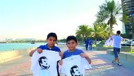 Children carrying T-shirts, distributed by Ooredoo, showing support for H H the Emir.
