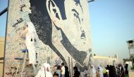 people signing on the Huge painting of Emir HH Sheikh Tamim bin hamad al Thani to show there solidarity with the leadership in this hour of crisis on Monday in Al Gharafa. Pic: Abdul Basit