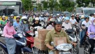 Motorcyclists cross an intersection in downtown Hanoi on July 4, 2017. Officials in Vietnam's traffic-clogged capital Hanoi vowed on July 4 to banish motorbikes by 2030 to ease environment and congestions woes, a decision that swiftly divided a city where