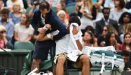 Serbia's Novak Djokovic gets some medical attention on court in a break between games against France's Adrian Mannarino during their men's singles fourth round match on the eighth day of the 2017 Wimbledon Championships at The All England Lawn Tennis Club