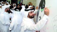 Qatar Football Association (QFA) Secretary General Mansoor Al Ansari signing a poster of the Emir H H Sheikh Tamim bin Hamad Al Thani at Al Bidda Tower yesterday. QFA representatives and office-bearers yesterday gathered around to sign the huge poster in 