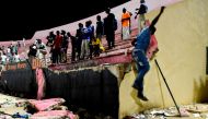 People look at the scene after a wall collapsed at Demba Diop stadium July 15, 2017 in Dakar after a football game between local teams Ouakam and Stade de Mbour. AFP / Seyllou