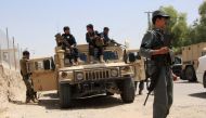 Afghan security personnel sit on atop an armoured vehicles amid an ongoing battle with Taliban militants in the Gereshk district of Helmand province on July 22, 2017. (AFP / NOOR MOHAMMAD)
