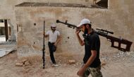 Syrian rebel fighters from the Faylaq al-Rahman brigade carry their homemade 12.7mm sniper rifle in Ain Tarma, in the eastern Ghouta area, a rebel stronghold east of the capital Damascus, on July 20, 2017. (AFP / ABDULMONAM EASSA)