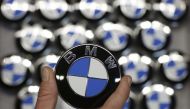 An employee holds a BMW logo on the production line of the BMW C evolution electric maxi-scooter at the BMW Berlin motorcycle plant, February 23, 2015 (REUTERS / Fabrizio Bensch) 