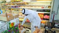 The Ministry of Economy and Commerce official conducting inspection at a fruit and vegetable shop in Doha.