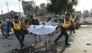 Pakistani rescue workers move the body of a victim at the site of an explosion in Lahore on July 24, 2017. (AFP / ARIF ALI)