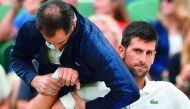 Novak Djokovic of Serbia gets some medical attention on court in a break between games against France’s Adrian Mannarino at the 2017 Wimbledon Championships in this July 11, 2017 file photo. 