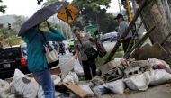 A woman walks through a barricade after a strike called to protest against Venezuelan President Nicolas Maduro's government in Caracas, Venezuela, July 28, 2017. (REUTERS/Ueslei Marcelino)