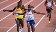 Winner Mo Farah (R) of Great Britain and runner up Joshua Kiprui Cheptegei (23) of Uganda celebrate after the men's 10,000 meters during the 