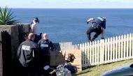A policeman jumps a fence at the home of John Ibrahim during a police operation in Sydney, Australia, August 8, 2017. (AAP/Brendan Esposito/via REUTERS)