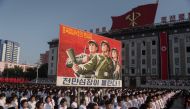 People wave banners and shout slogans as they attend a rally in support of North Korea's stance against the US, on Kim Il-Sung square in Pyongyang on August 9, 2017. AFP / Kim Won-Jin