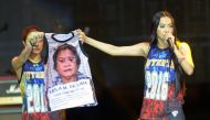 Mocha Uson (R), a blogger and supporter of Philippine President Rodrigo Duterte, onstage with her colleague displaying a T-shirt decorated with a mugshot of arrested legislator Senator Leila De Lima during a pro-Duterte rally at a park in Manila. (AFP / T