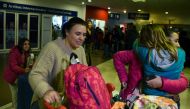 Valeria Marsili (2-L), wife of Gabriel Aguero, an Argentinean chef who works in Qatar, and their daughters are greeted by a relative upon her arrival at Ezeiza international airport in Buenos Aires on August 09, 2017. (AFP / EITAN ABRAMOVICH)