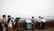 FILE PHOTO: Visitors look toward a North Korean village through a pair of binoculars at a shopping mall near the demilitarized zone separating the two Koreas in Paju, July 16, 2017 (REUTERS / Kim Hong-Ji) 