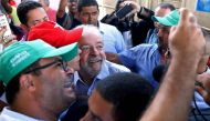 Former Brazilian President Luiz Inacio Lula da Silva (C) poses for pictures as he meets farmers during his 