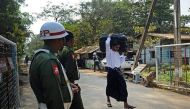 A former Myanmar child soldier (R) carries his belongings as he walks out from a military compound in Yangon after a ceremony discharging a group of children in 2014. / AFP.