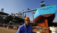 (FILES) This file photograph taken on February 15, 2008, shows a worker stands in front of an under-construction 300,000-tonne oil tanker for Danish shipping company Maersk and an under-construction offshore drilling platform at a shipyard in northeast Ch