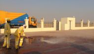Workers cleaning a Eid prayer yard.