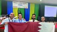 Students pose for a picture with Qatar’s flag. 