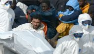 This April 20, 2015 photo shows rescuers carrying the body of a victim after coast guards followed a wrecked vessel off the coasts of Libya.  (AFP / Matthew Mirabelli) 