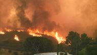 Flames from the La Tuna Fire blaze on a hill in the Shadow Hills neighborhood of Los Angeles, California, September 2, 2017. The La Tuna fire exploded to 8,000 acres on September 2, 2017, prompting mandatory evacuations and destorying three structures. It