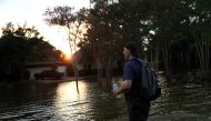 Samir Novruzov walks through a flooded street on September 4, 2017 in Katy, Texas. / AFP.