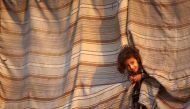 A displaced Syrian child who fled the Islamic State (IS) group's Syrian stronghold of Raqa as fighters from a US-backed coalition battle to retake the city, stands at an abandoned house where people take refuge in the town of Tabqa, about 55 kilometres (3