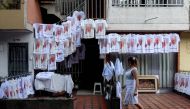 A woman walks by a display of t-shirts for sale outside the Olaya Herrera airport the day before Pope Francis celebrates an open air mass in Medellin, on September 8, 2017.  AFP / JOAQUIN SARMIENTO
