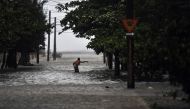 A man wades through a flooded street during the passage of Hurricane Irma, in Havana, on September 9, 2017. Irma's blast through the Cuban coastline weakened it to a Category Three, but it is still packing winds of 125 miles (200 kilometer) per hour. / AF