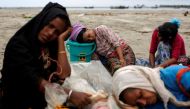 Exhausted Rohingya refugees rest on the shore after crossing the Bangladesh-Myanmar border by boat through the Bay of Bengal in Shah Porir Dwip, Bangladesh, September 10, 2017. Reuters/Danish Siddiqui