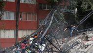 People climb over the debris of a collapsed building after an earthquake hit Mexico City, Mexico September 19, 2017. Picture taken September 19, 2017. REUTERS/Ginnette Riquelme.